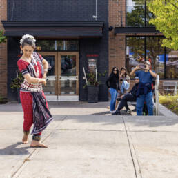 A woman in traditional costume dances in front of Jack Astor’s during Mushtari Afroz’s Choreo-xperience Public Spaces, 2023.