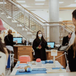 Myung-Sun Kim stands in the centre of the image, talking about her exhibition Rituals for Belonging at Toronto Public Library – Lillian H. Smith Branch, 2023.