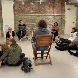 A group of people sit in a circle talking at a Kevin A. Ormsby workshop, 2023.