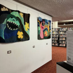 On the right Alisa McRonald’s textile work hangs on the wall near the Toronto Reference Library Exhibition at the Toronto Public Library, 2023.